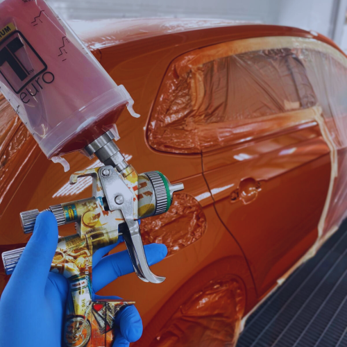 Application d’une peinture automobile orange dans la cabine de la Carrosserie du Relais SA à Sonceboz-Sombeval, Jura bernois.