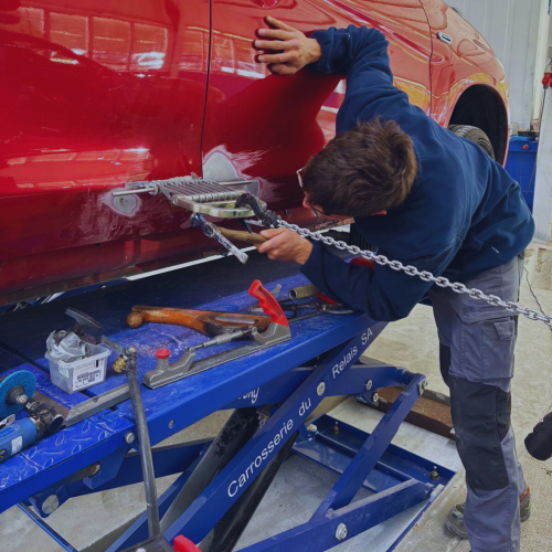 Carrossier effectuant un travail de redressage de tôle sur un véhicule dans l’atelier de la Carrosserie du Relais SA à Sonceboz-Sombeval, Jura bernois